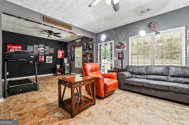 a living room with furniture a flat screen tv and a floor to ceiling window