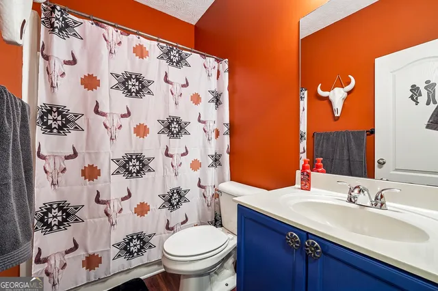 a bathroom with a sink and mirror with toilet