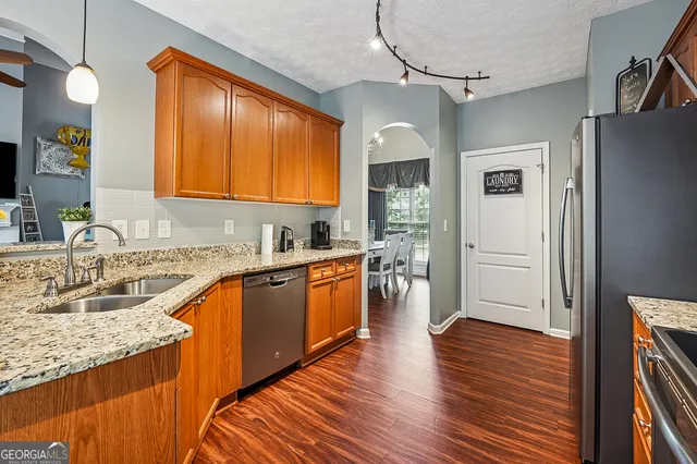 a kitchen with stainless steel appliances granite countertop wooden floors and sink