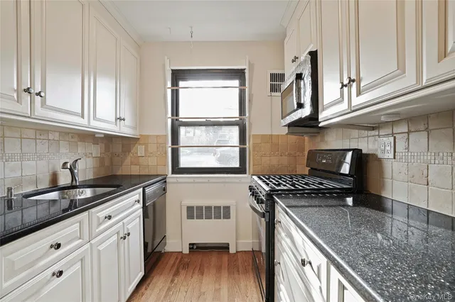 a kitchen with stainless steel appliances granite countertop a sink stove and cabinets