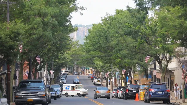 a view of city street with cars parked on the roadside