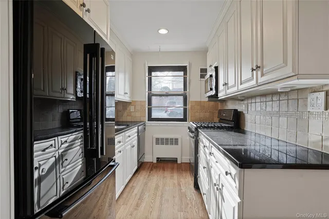 a kitchen with granite countertop a sink stove and cabinets