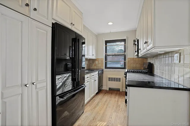 a kitchen with white cabinets and appliances