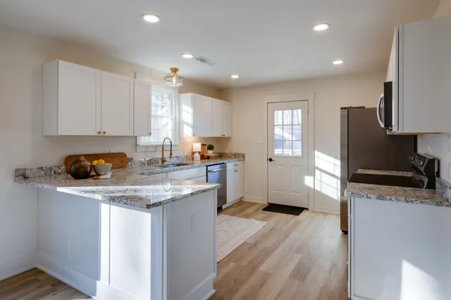 a kitchen with stainless steel appliances granite countertop a sink stove and refrigerator