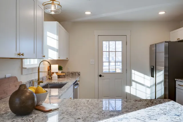 a kitchen with a refrigerator and a stove top oven