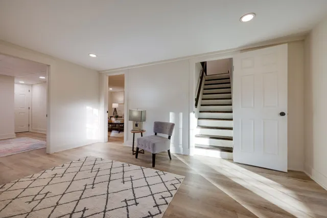 a view of an empty room with stairs and a chair