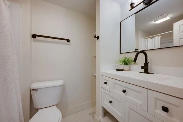 a bathroom with a toilet a sink and mirror