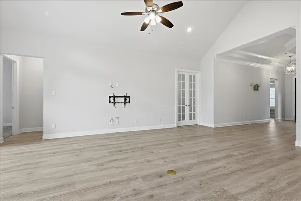 a view of an empty room with window and wooden floor
