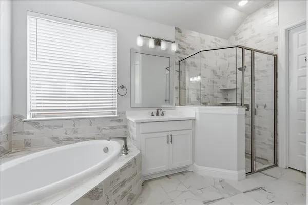 a bathroom with a tub sink and mirror