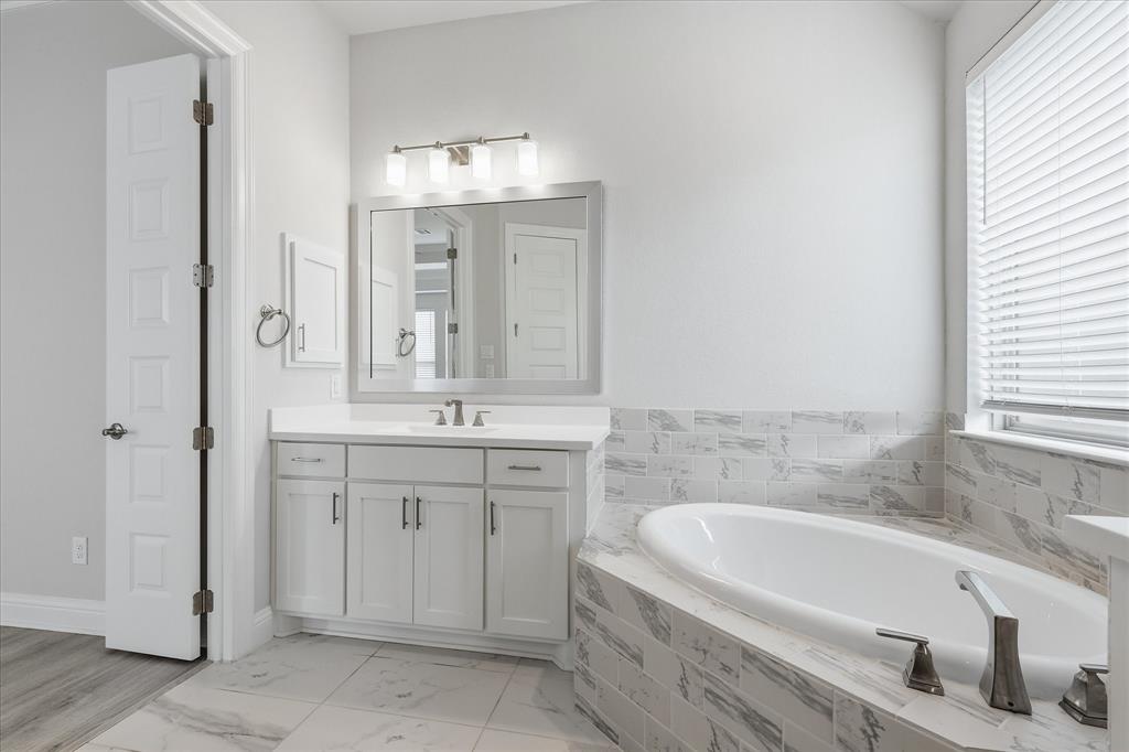 910 Cone Flower Drive Prosper, TX 75078 - Photo 24 of 40 a bathroom with a bathtub sink and mirror