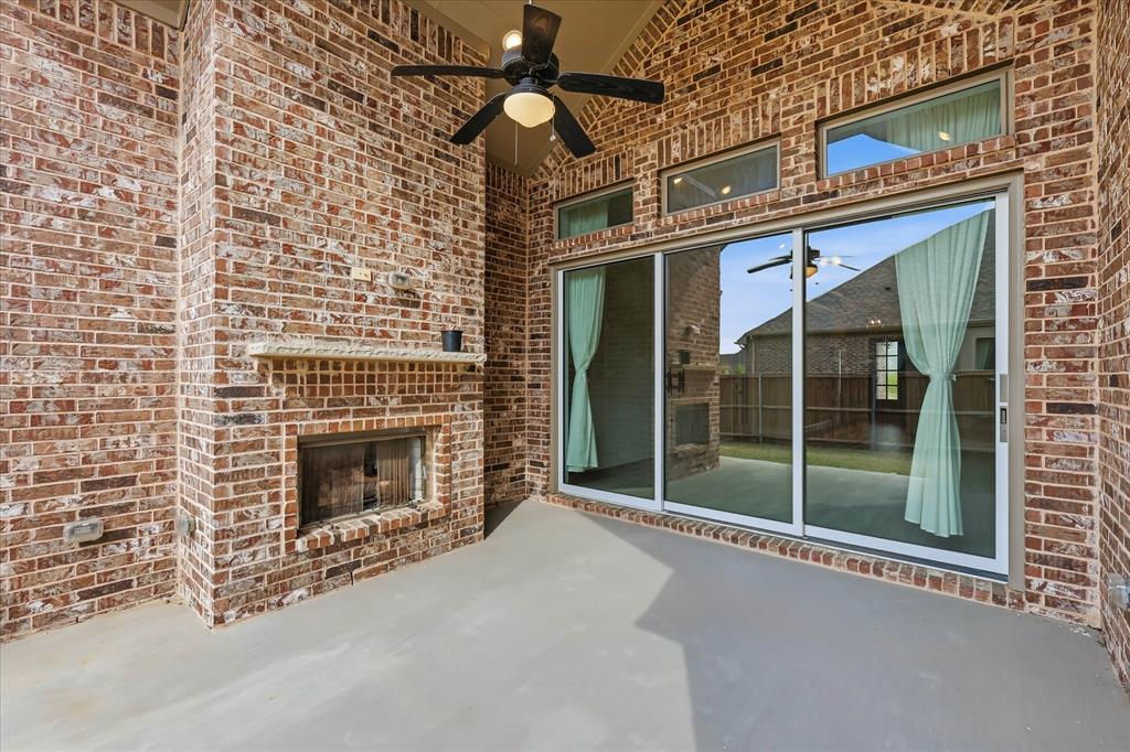 910 Cone Flower Drive Prosper, TX 75078 - Photo 32 of 40 a living room with a fireplace and a rug