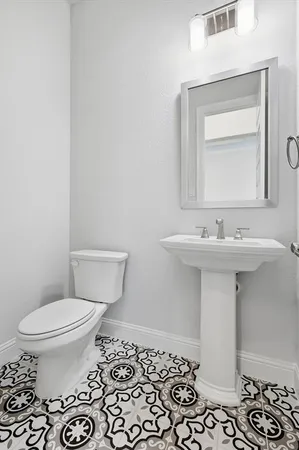 a bathroom with a sink toilet and mirror