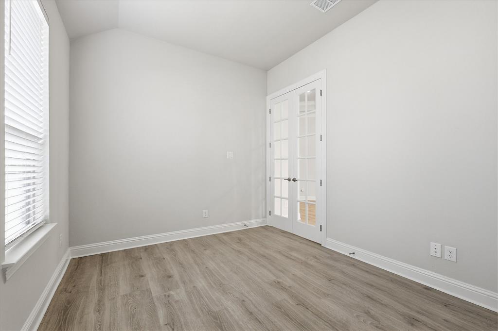 910 Cone Flower Drive Prosper, TX 75078 - Photo 8 of 40 an empty room with wooden floor and windows