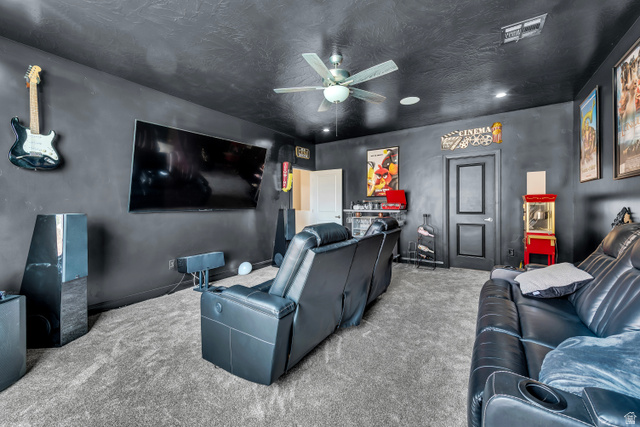 6105 Bunda Way St. George, UT 84790 - Photo 24 of 49 Dedicated media room featuring dark walls, textured ceiling, and gray carpeting