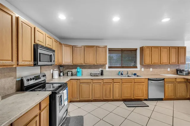 a kitchen with lots of counter top space appliances and a sink