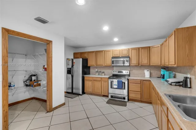 a kitchen with a sink a refrigerator and cabinets