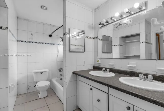 a bathroom with a granite countertop sink a toilet and a mirror