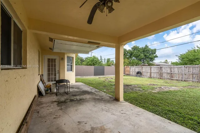 a view of a chair and table in backyard of the house