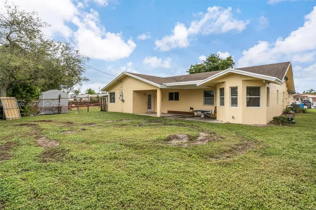 a view of a yard in front of a house with large trees