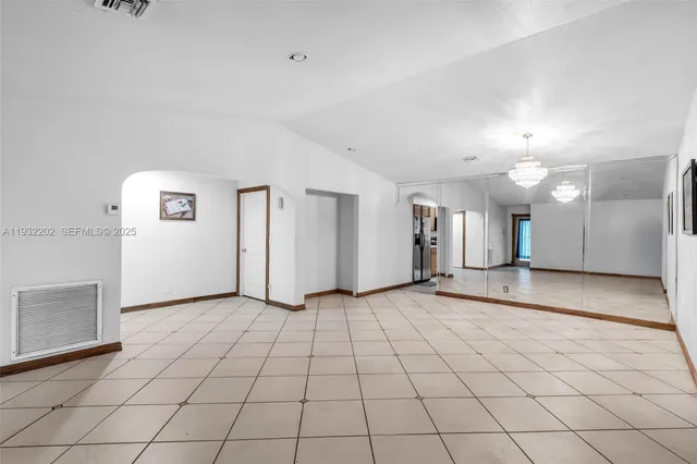 an empty room with fireplace and windows