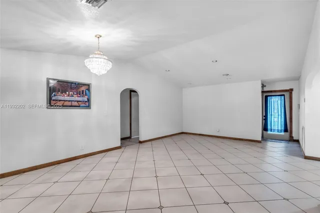 an empty room with chandelier fan
