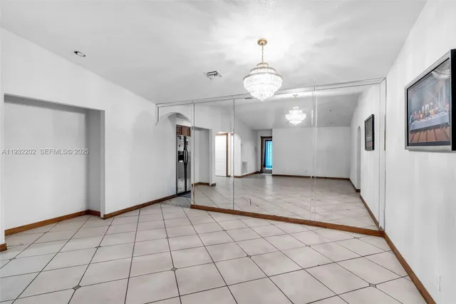 a view of a hallway with wooden floor and chandelier
