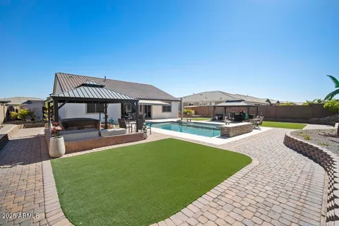 a large kitchen with granite countertop a dining table chairs wooden cabinets and stainless steel appliances