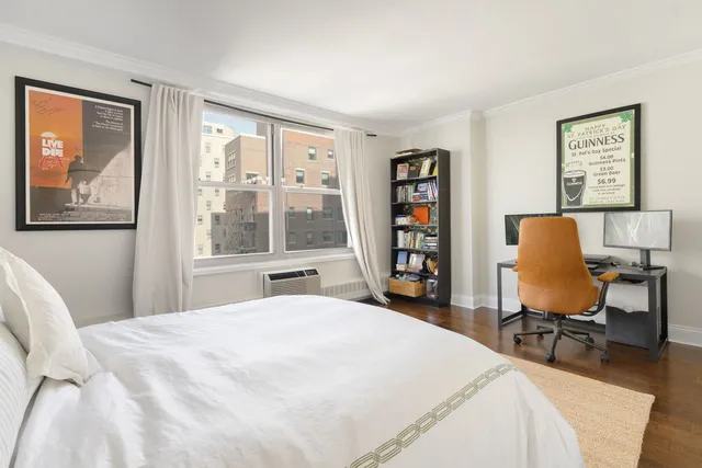 a bedroom with a bed a table and a large window