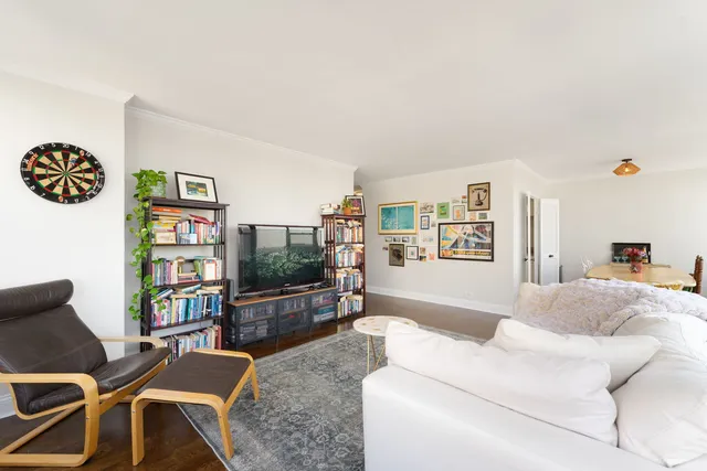 a living room with furniture a flat screen tv and a bookshelf