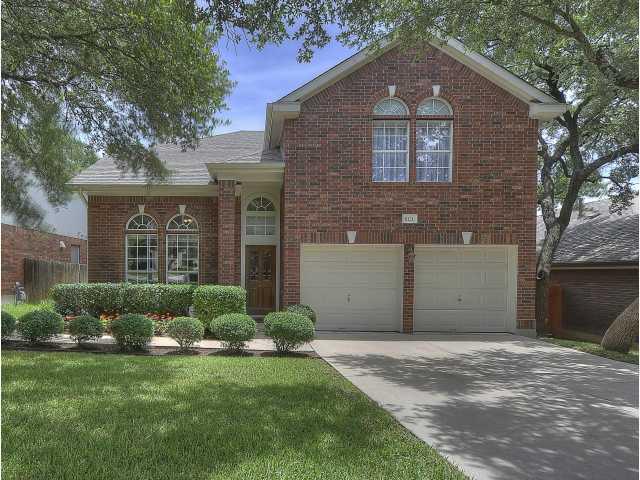 Traditional-style house featuring a garage, brick siding, and concrete driveway