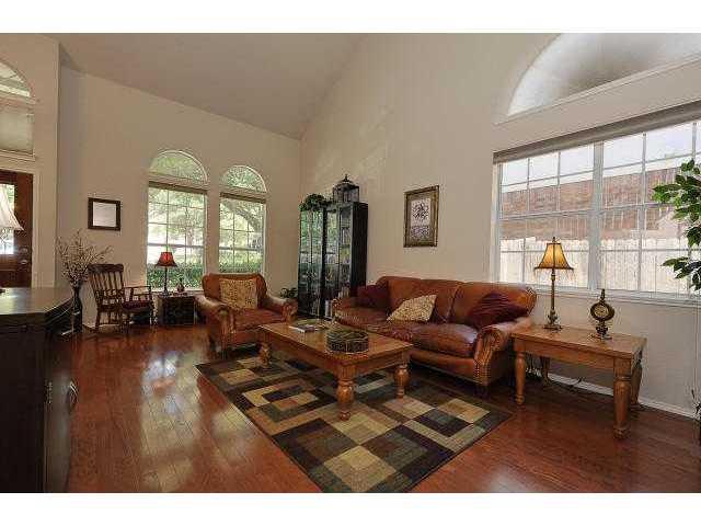 8121 Siringo Pass Austin, TX 78749 - Photo 2 of 9 Living area featuring dark wood-style floors and vaulted ceiling
