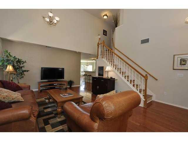 8121 Siringo Pass Austin, TX 78749 - Photo 3 of 9 Living room with a high ceiling, wood finished floors, and a chandelier