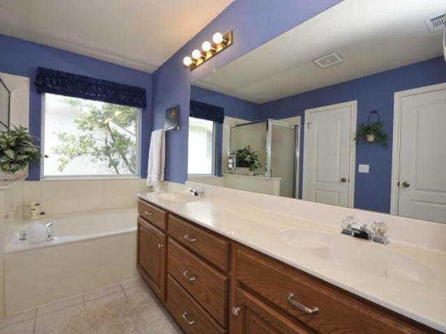 8121 Siringo Pass Austin, TX 78749 - Photo 8 of 9 Bathroom featuring double vanity, a bath, a shower stall, and light tile patterned floors
