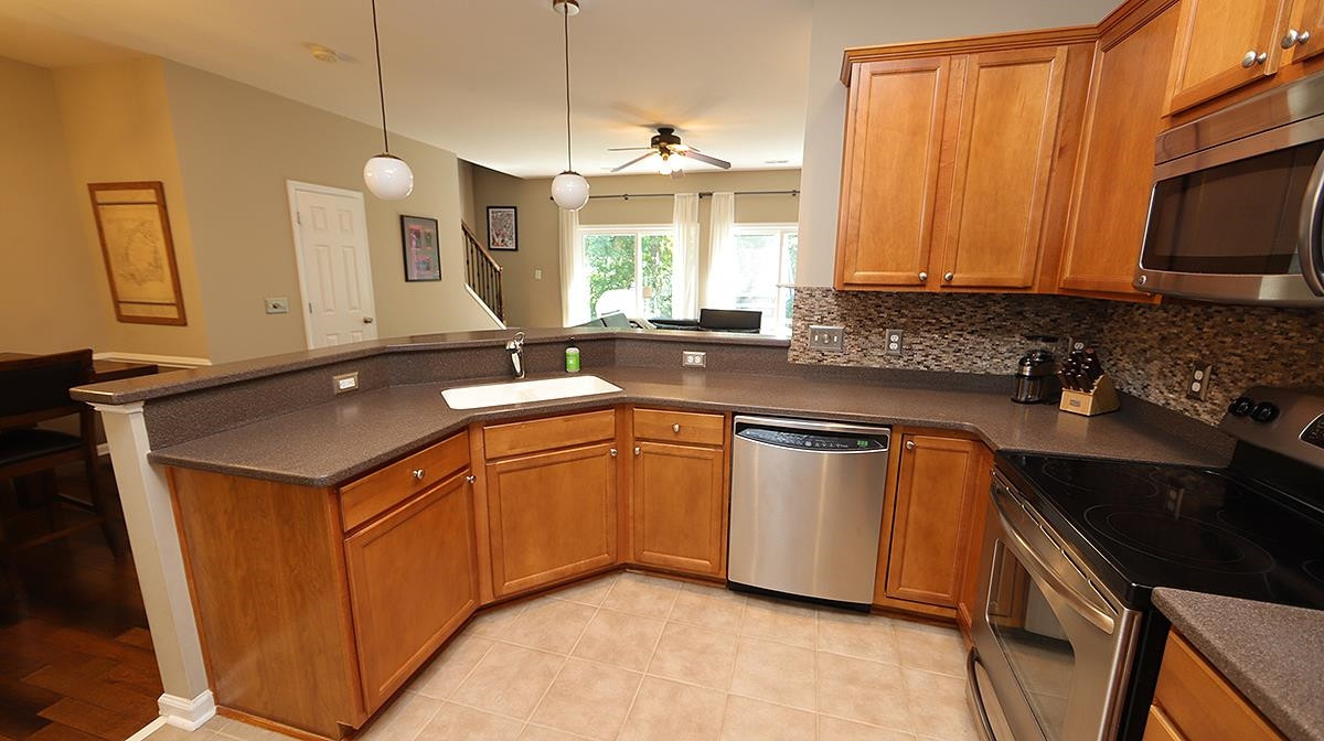7020 Racine Way Raleigh, NC 27690 - Photo 7 of 26 Everything you could want in a Kitchen with a view out back, tile backsplash, under cabinet lighting, and stainless steel appliances. Kitchen