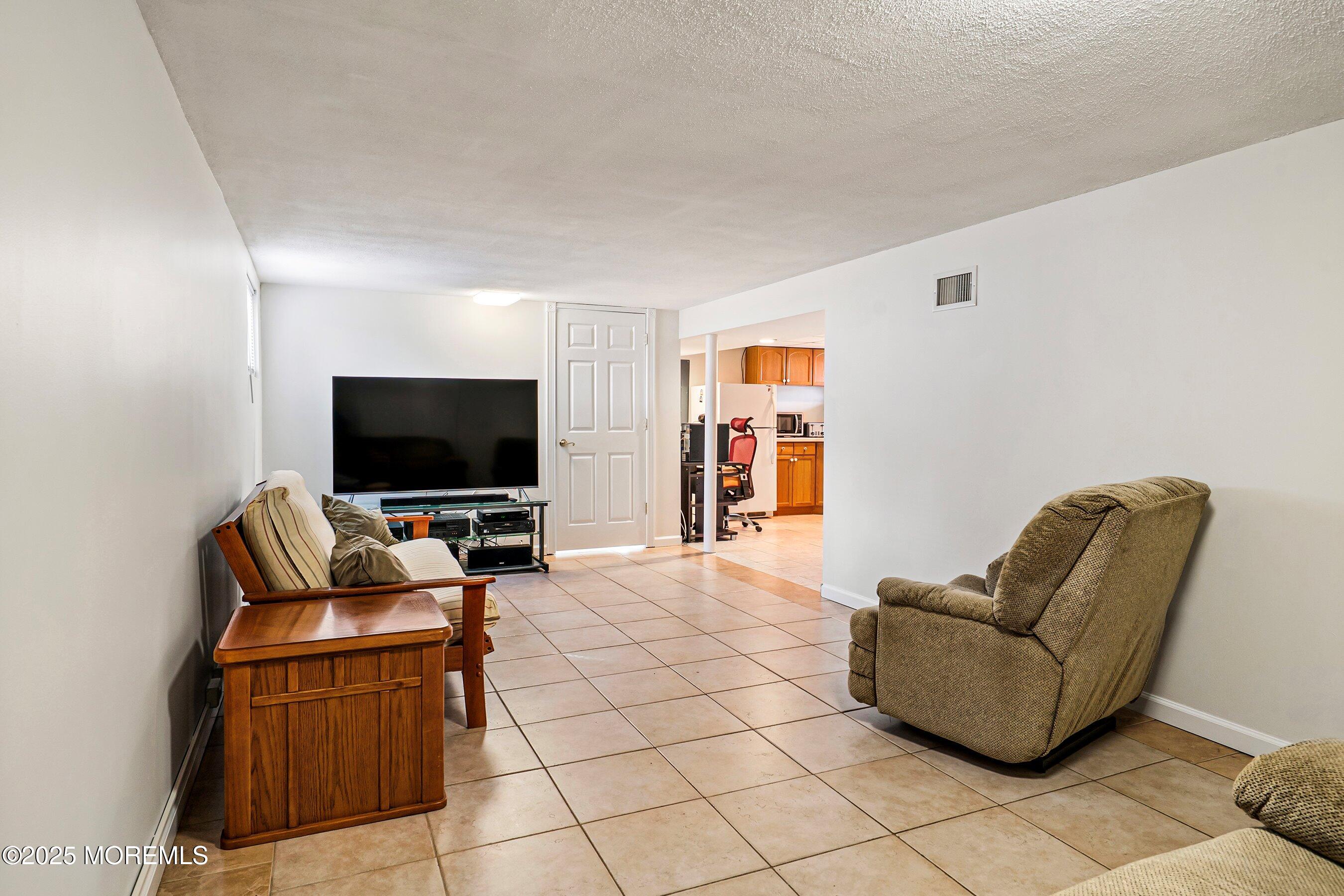 501 Stone Road Union Beach, NJ 07735 - Photo 17 of 30 a living room with furniture and a flat screen tv