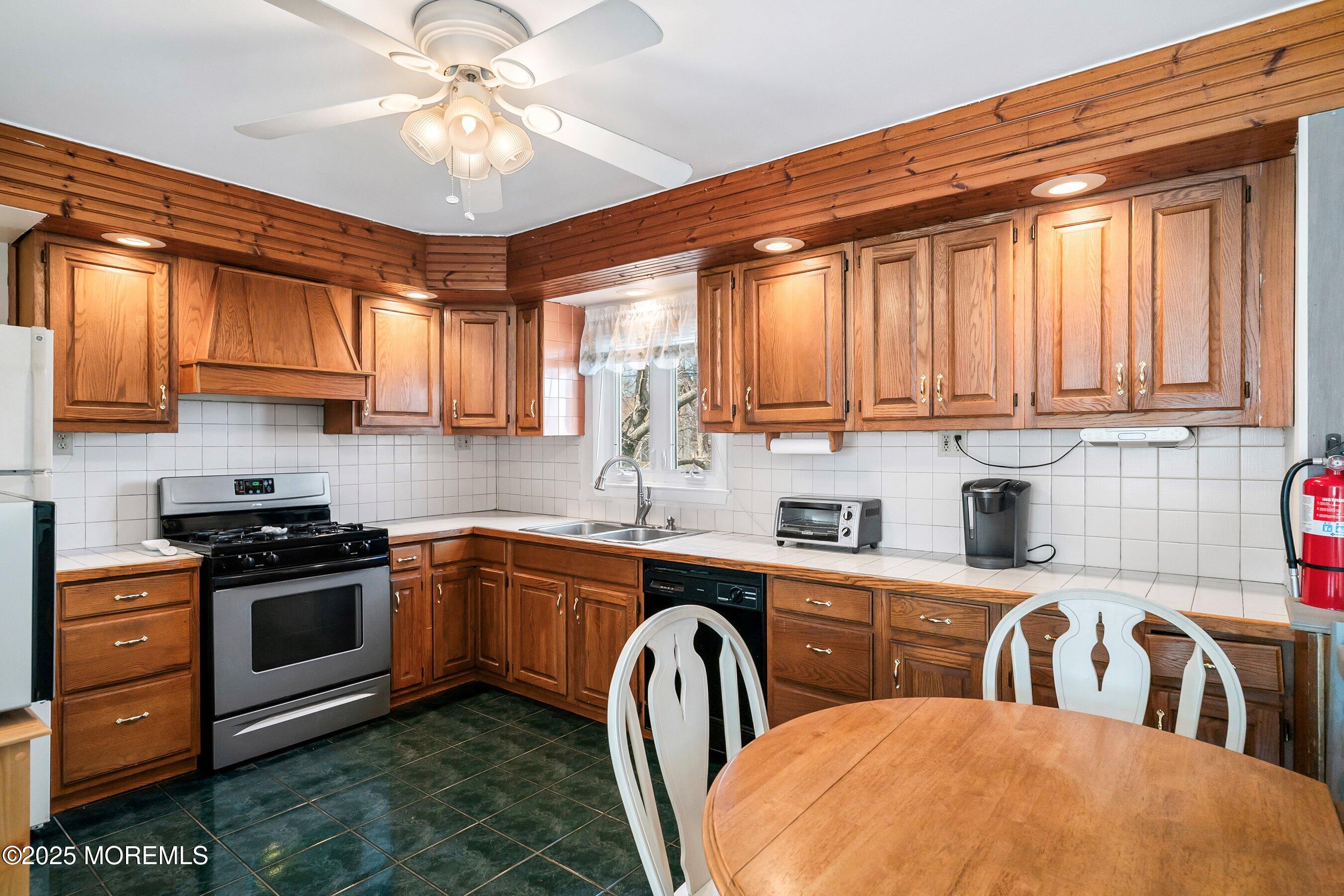 501 Stone Road Union Beach, NJ 07735 - Photo 7 of 30 a kitchen with stainless steel appliances granite countertop a stove a sink dishwasher and cabinets with wooden floor