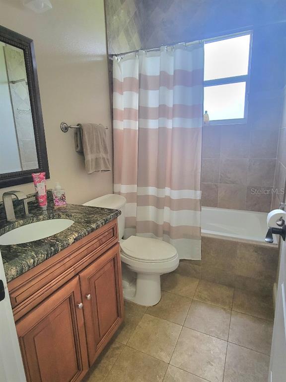 12625 Sweet Hill Road Polk City, FL 33868 - Photo 16 of 32 a bathroom with a granite countertop sink a toilet a mirror and shower