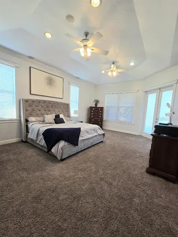 a spacious bedroom with a bed and a chandelier