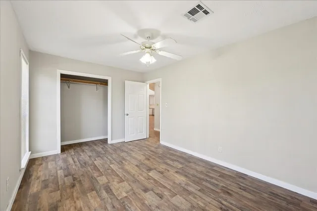 a view of an empty room with wooden floor