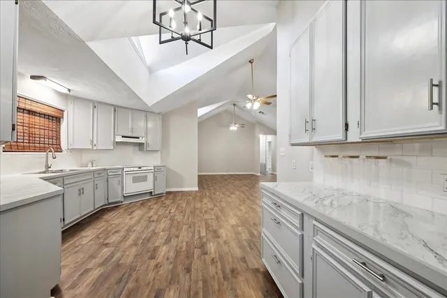 a large kitchen with cabinets wooden floor and stainless steel appliances