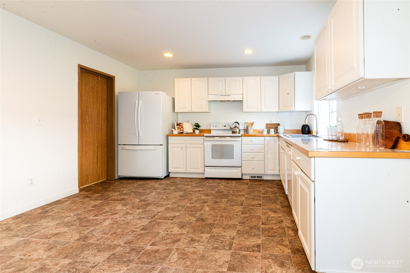 2322 Southeast 2nd Court Renton, WA 98056 - Photo 8 of 27 a kitchen with a sink a refrigerator and cabinets