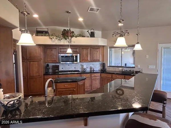 a kitchen with kitchen island granite countertop a sink cabinets and window