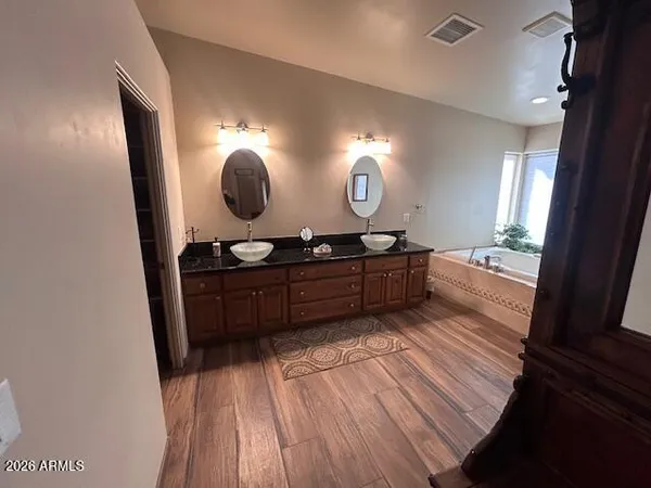 a spacious bathroom with a granite countertop sink and a mirror