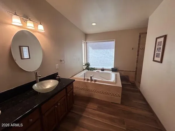 a bathroom with a granite countertop double vanity sink and a mirror