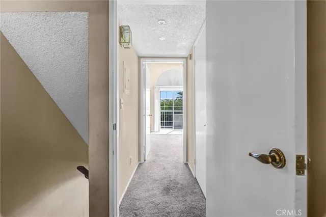 a view of a hallway with wooden floor and a bathroom