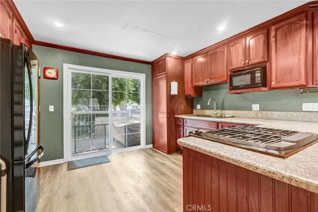a kitchen with stainless steel appliances granite countertop a stove a refrigerator and a wooden cabinets