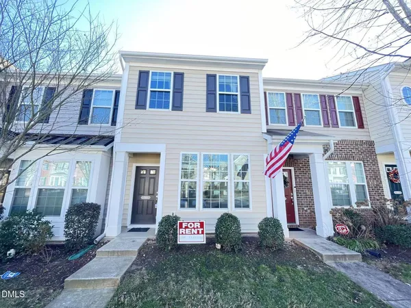 a front view of a house with a garden and plants