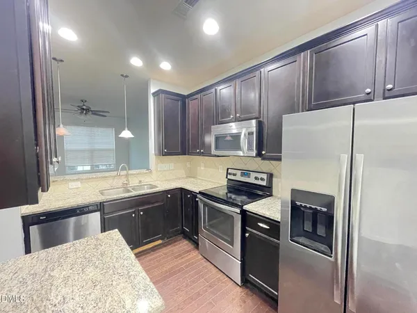a kitchen with stainless steel appliances granite countertop a refrigerator stove and sink
