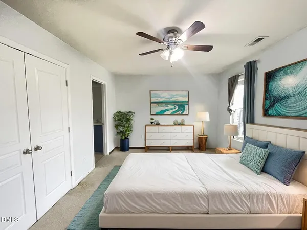 a bedroom with a large bed and a chandelier