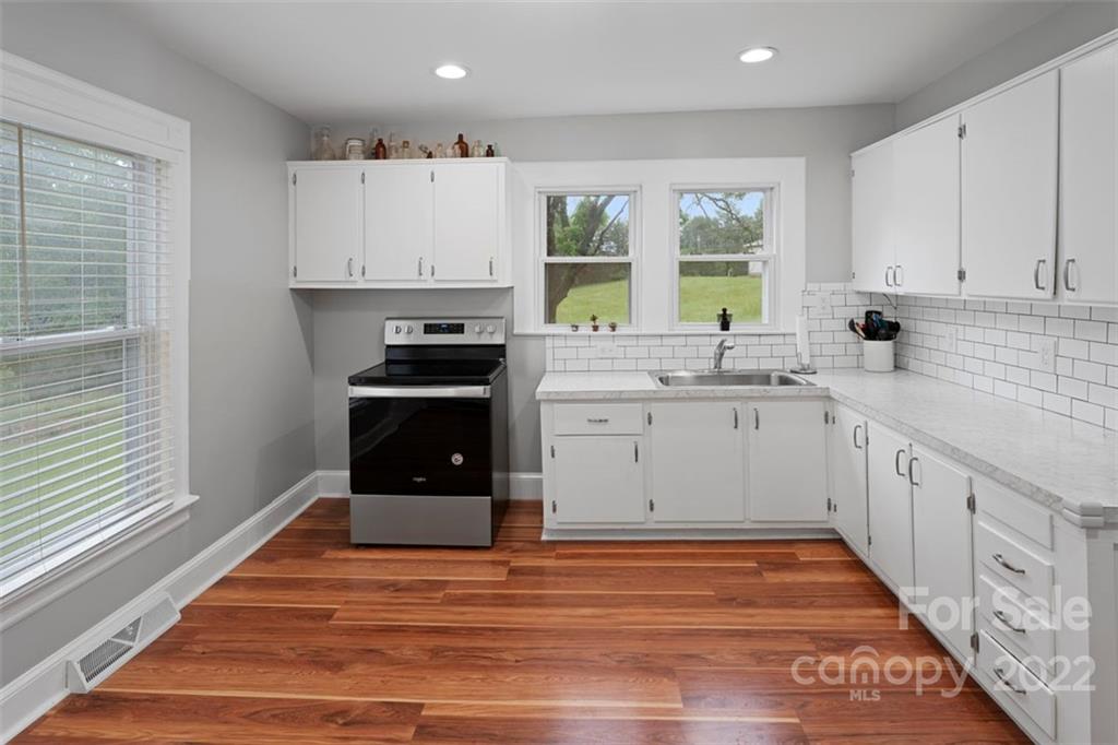 2139 Quaker Road Siloam, NC 27047 - Photo 20 of 35 a kitchen with stainless steel appliances granite countertop a stove a sink and a refrigerator